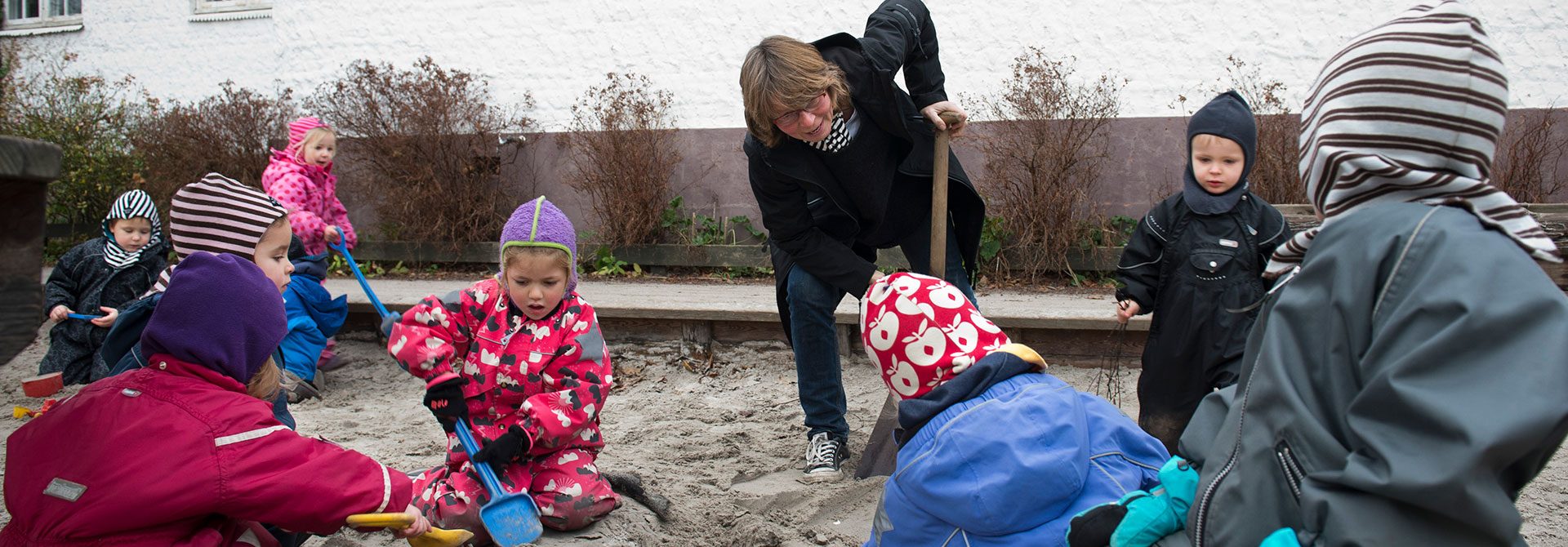 Fagbevægelsens Hovedorganisation: Pædagog leger i sandkasse med nogle børnehavebørn