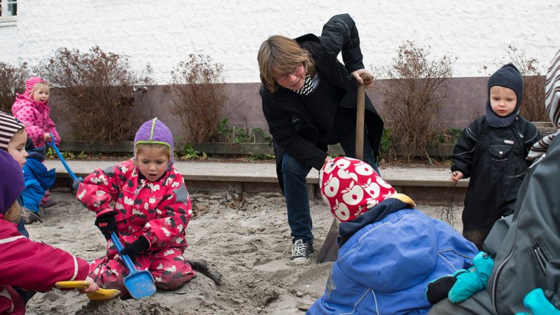 Fagbevægelsens Hovedorganisation: Pædagog leger i sandkasse med nogle børnehavebørn