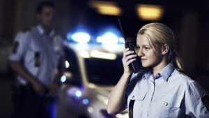 Kvindelig politibetjent taler i telefon. Fagbevægelsens Hovedorganisation