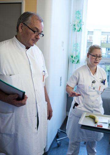 Læge og sygeplejerske drøfter behandling af en patient