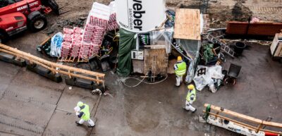 Byggeplads med tre bygningsarbejdere set fra oven